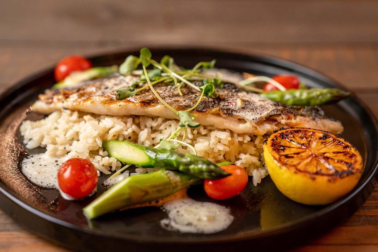 Branzino on a plate with rice and vegetables