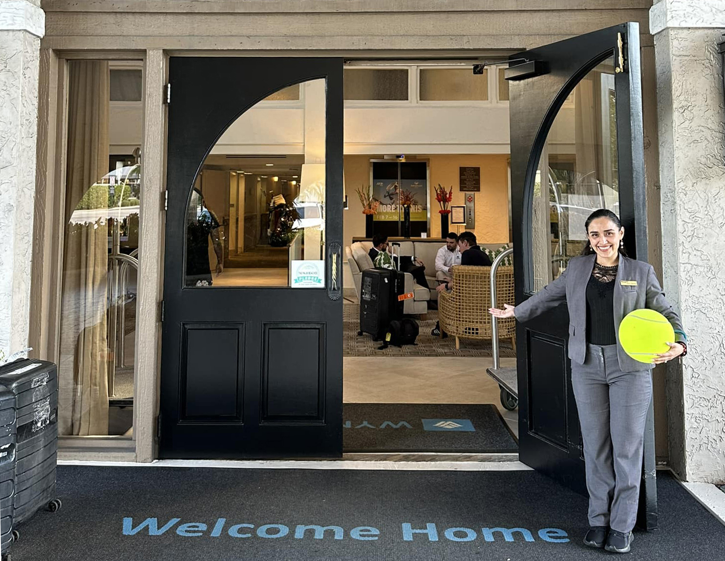 Woman welcoming people into hotel