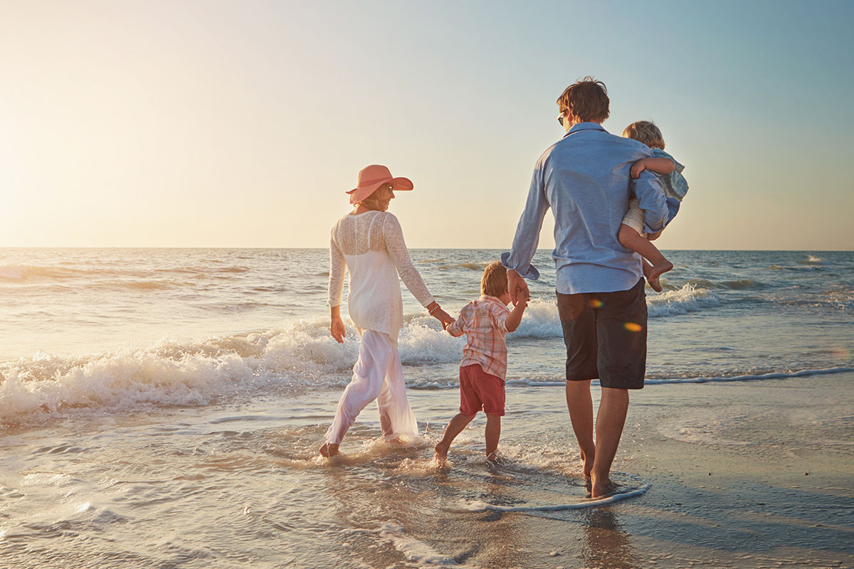 Family of four walking on the beach