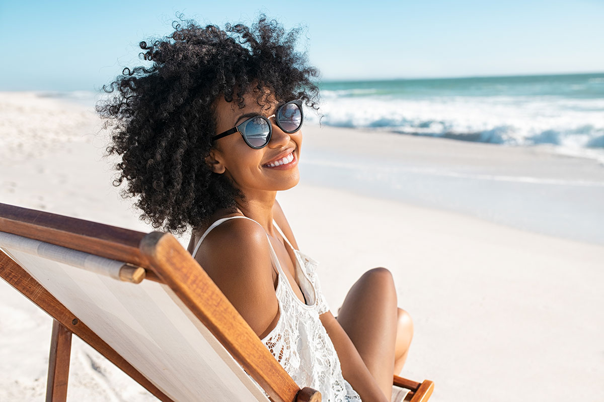 Woman wearing sunglasses on a beach chair